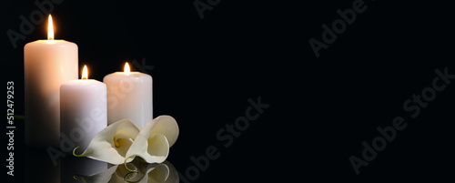 Fotografia Burning candles and flowers on black background with space for text