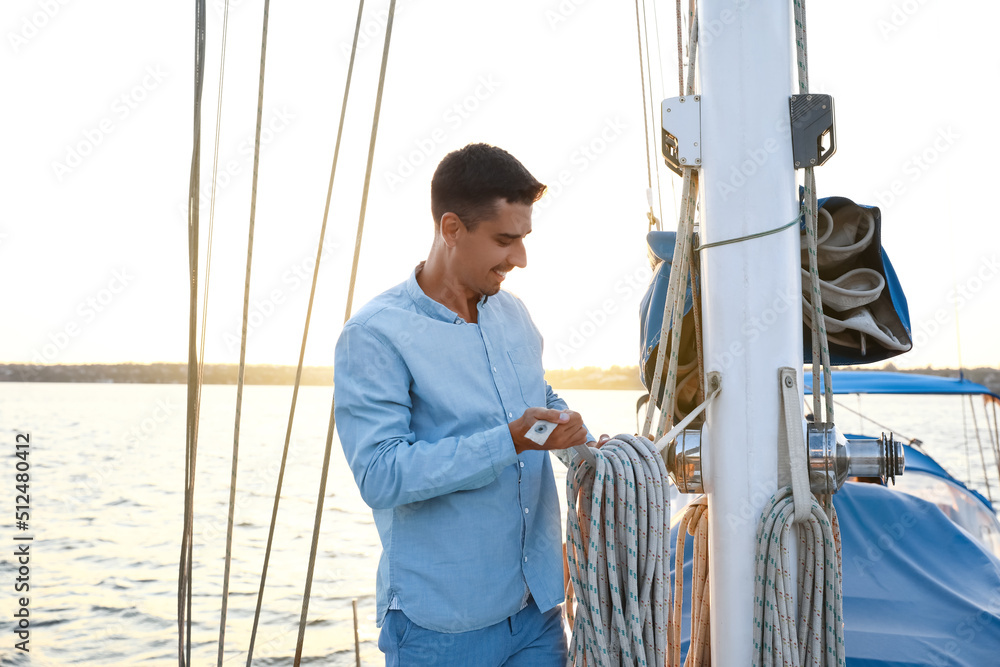 Obraz premium Young man adjusting the rigging of his yacht