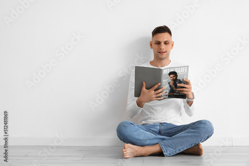 Young barefoot man reading ...