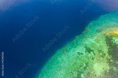 Top view of a steep drop-off at a coral reef at Pangangan Island, Calape, Bohol, Philippines. Shallow waters that suddenly drop into the deep blue ocean. photo