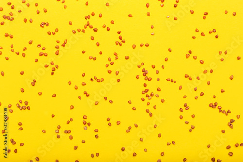 Scattered buckwheat grains on yellow background