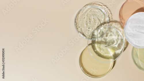 Various cosmetic products in Petri dishes on beige background view from above. Copy space photo