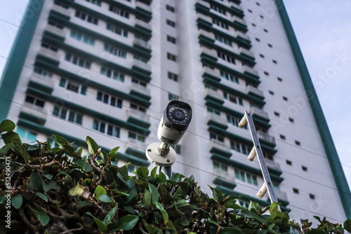 Residential condominium security system - Security camera and electric fence with building in the background