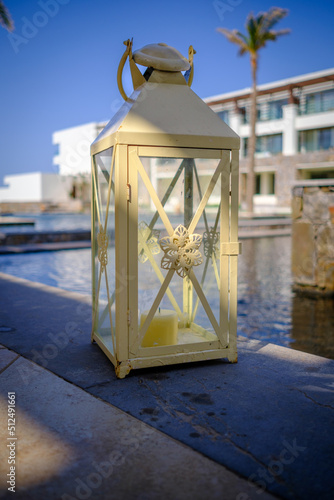  lantern stands next to a swimming pool