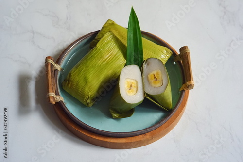 a plate of traditional cake from rice flour and banana wrapped in banana leaves named nagasari  photo