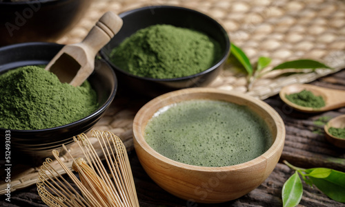 Japanese organic matcha green tea powder in bowl with wire whisk and green tea leaf on wooden background, Organic product from the nature for healthy with traditional style