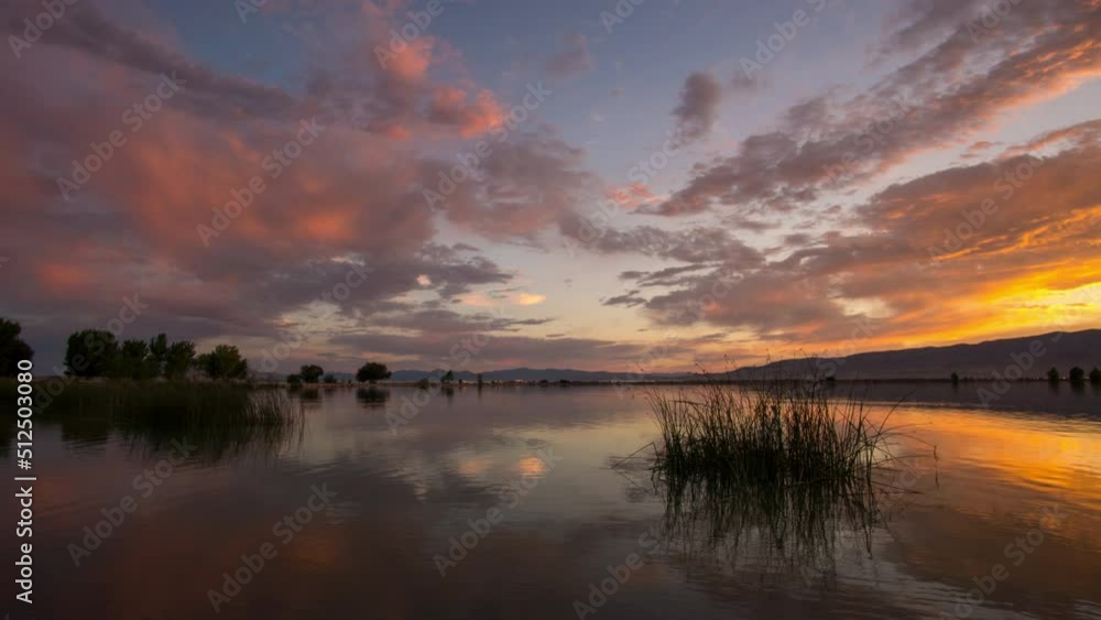 Time lapse reflecting colorful sunset in Utah Lake as the color fades away. Time lapse reflecting colorful sunset in Utah Lake as the color fades away.