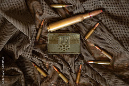 Pili lie on a green background and next to it lies a stripe with the flag of Ukraine, the war in Ukraine, ammunition