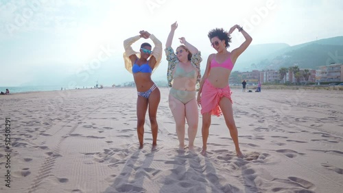 Beautiful multiethnic young women having fun on the beach during the summetime vacation. Storytelling representation of body positivity, self acceptance and individuality female concepts photo