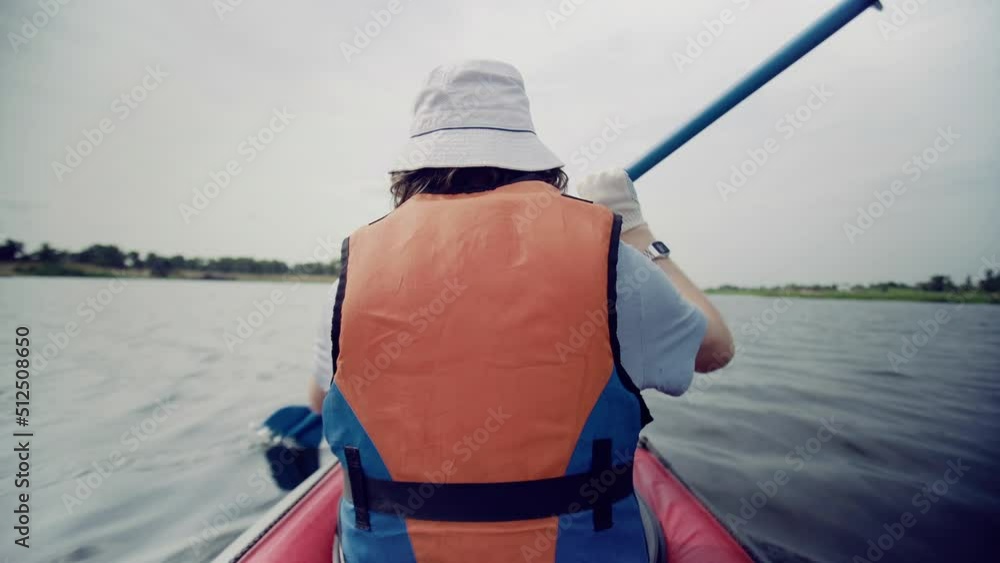 A young man is kayaking on the river against a beautiful landscape. Travel. Tourism.