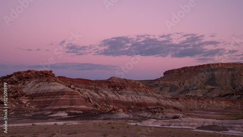 Desert sunrise timelapse in Utah with striped rock mounds like Mars might look as the sun lights up the sky and landscape. photo