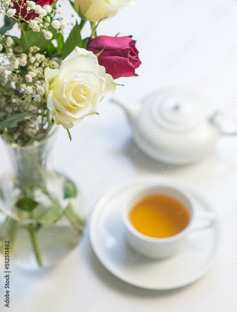 Vertical high angle closeup of white rose with tea cup and teapot in background (selective focus) Vertical high angle closeup of white rose with tea cup and teapot in background (selective focus)