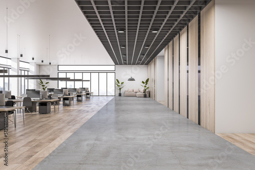 Fototapeta Naklejka Na Ścianę i Meble -  Front view on concrete floor area in modern open space office with lounge sofa, rows of work places with modern computers and wooden decorated walls. 3D rendering