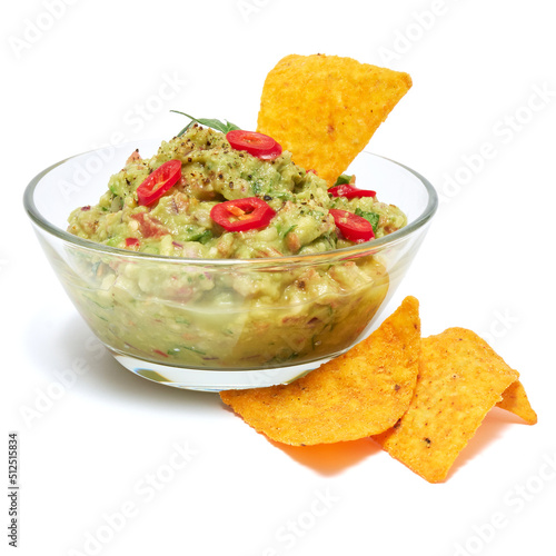 Healthy vegetarian organic guacamole Mexican dip sauce served in glass bowl with nachos or tortilla chips isolated on white background