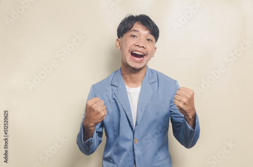 young asian man wearing college suit with excited expression photo