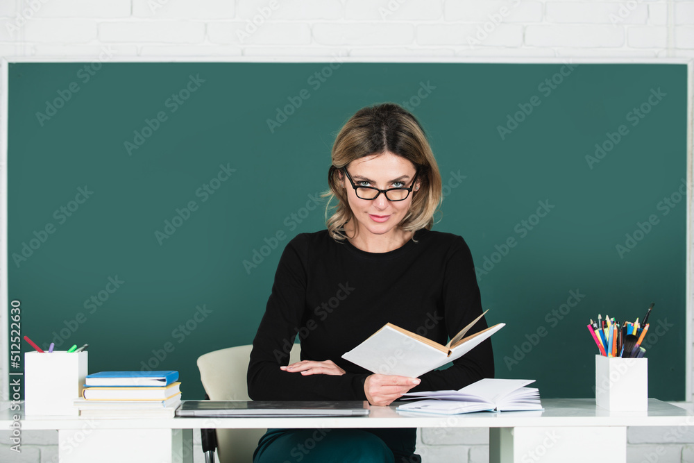 Portrait of teacher or female tutor working at table in college or high school. Young women student studying in class. Education and tutoring concept. Portrait of teacher or female tutor working at table in college or high school. Young women student studying in class. Education and tutoring concept.