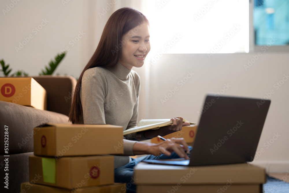 Asian woman Running Business From Home. Shipping shopping online, young start up small business owner packing cardboard box at workplace. Online selling or e-commerce