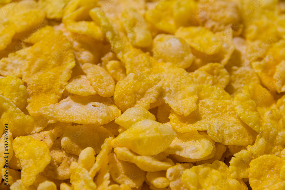 Delicious cornflakes close up, yellow textured food background with copy space Delicious cornflakes close up, yellow textured food background with copy space