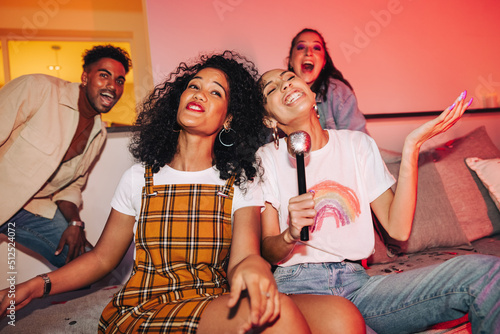 Girlfriends entertaining their friends on karaoke night