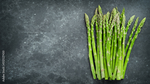 Bunch of green asparagus on dark concrete background. Copy space  top view