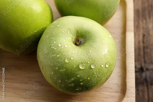 green apples. Fresh ripe green apple with water drops on wooden plate.