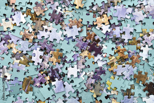 Stack of scattered colorful pieces of jigsaw puzzle. Top view. Close-up. 

