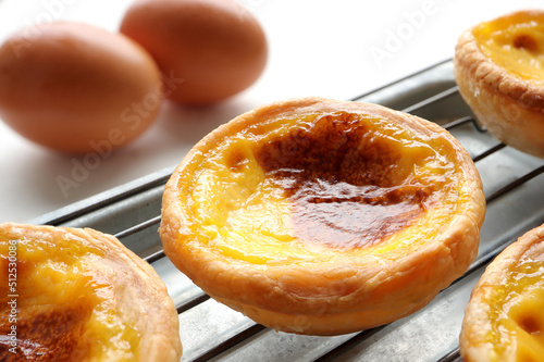 Closeup of Egg tart or portuguese egg tart. golden delicious new baked tart on wooden background.
