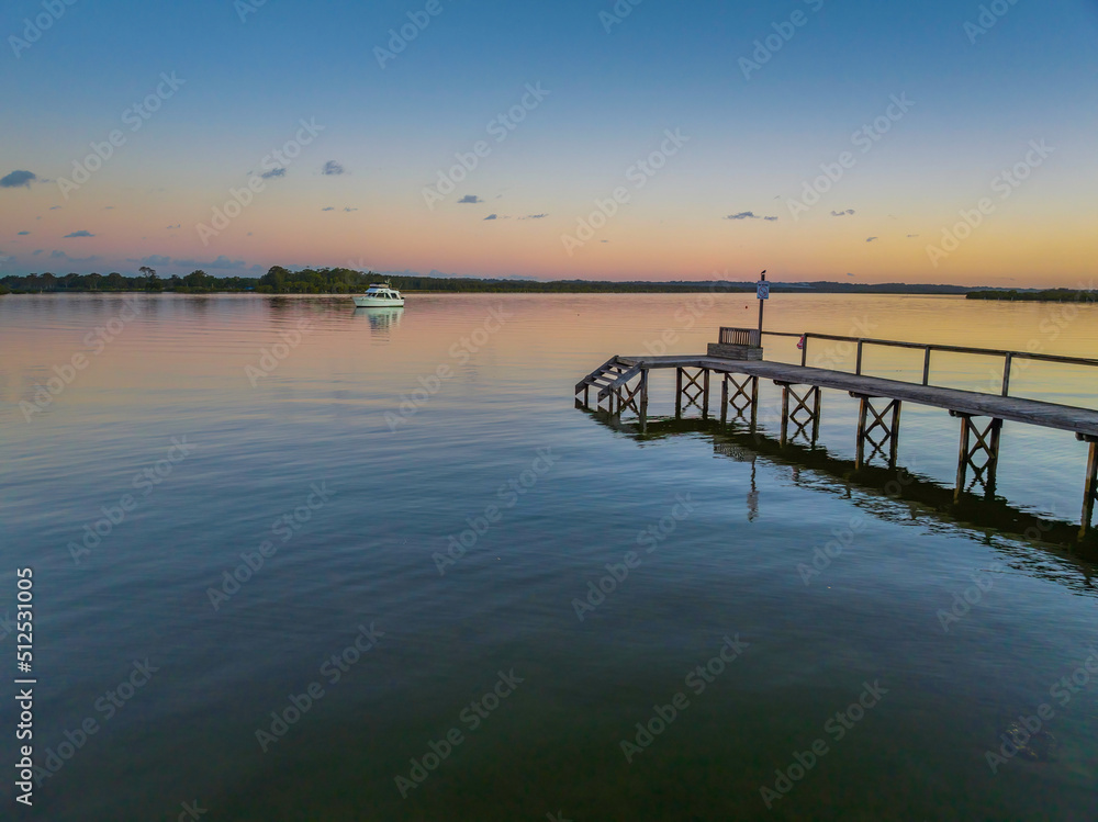 Sunset over the river with boat and wharf