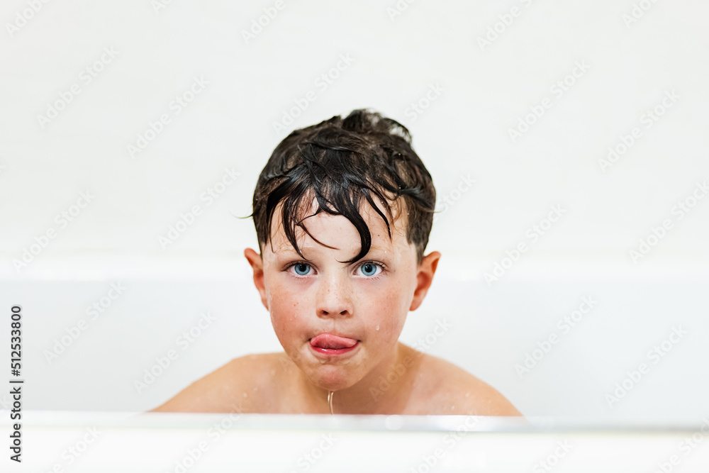 Boy doing funny face while sitting in bathtub Boy doing funny face while sitting in bathtub