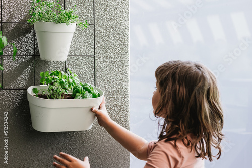 Girl hanging flowerpot on wall photo