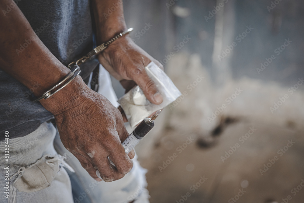 Drug traffickers were arrested along with their heroin. Police arrest drug trafficker with handcuffs. Law and police concept,26 June, International Day Against Drug Abuse and Illicit Trafficking