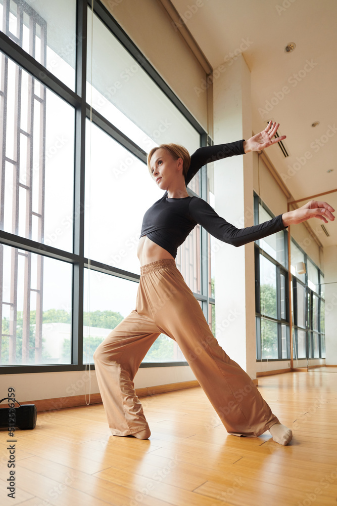 Female contemporary dancer enjoying dancing alone in empty studio Female contemporary dancer enjoying dancing alone in empty studio