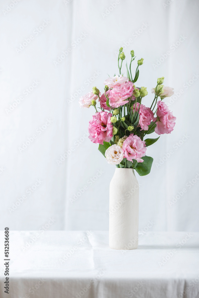 Fototapeta premium Pink lisianthus flowers in white vase