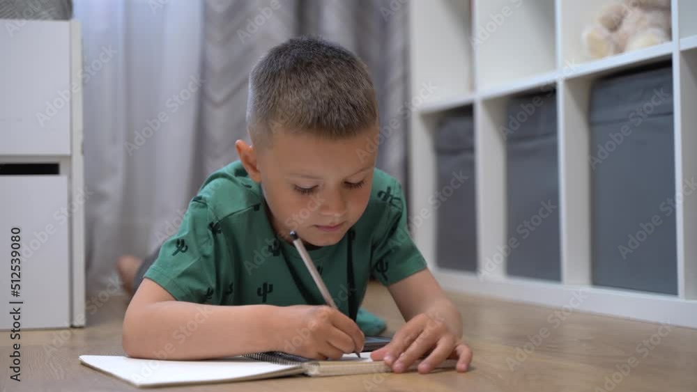 Boy draws while watching a lesson on the phone