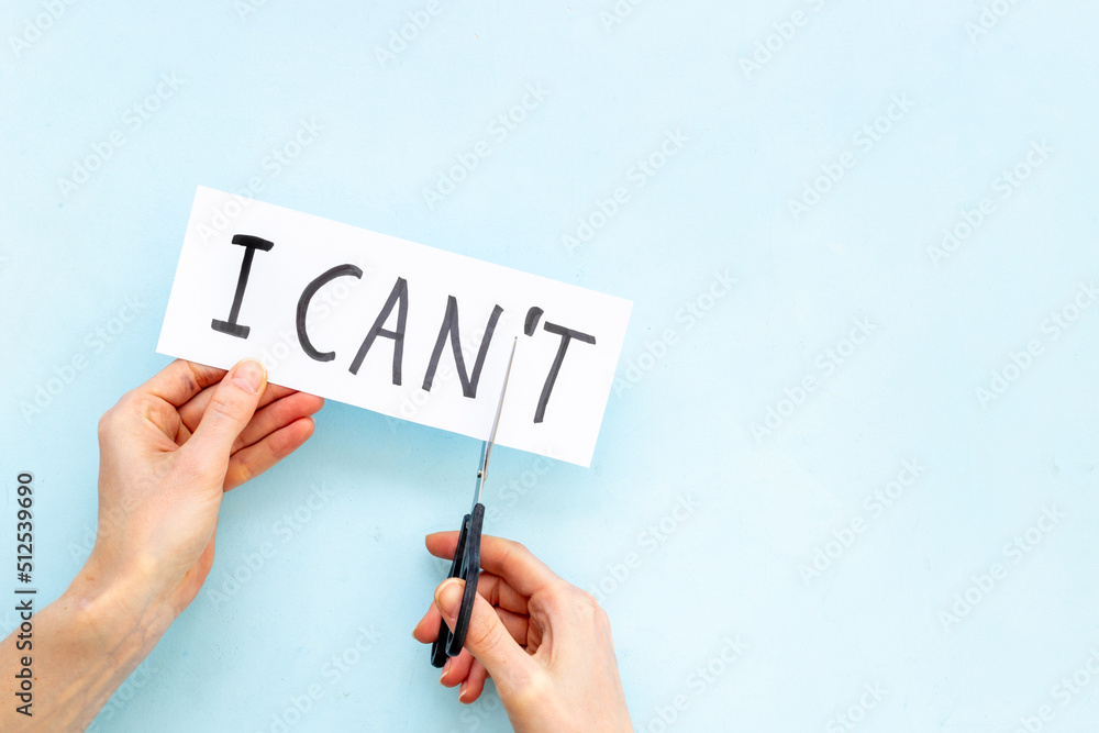 Hands cutting card with text I cannot into I can. Motivation concept Hands cutting card with text I cannot into I can. Motivation concept