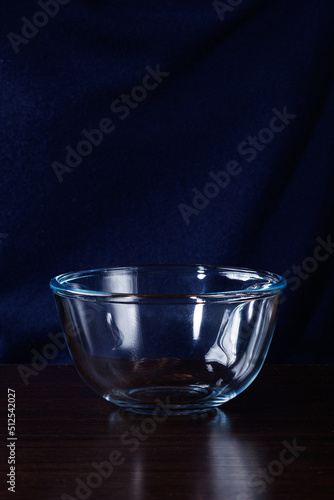 Empty clean and transparent glass bowl on a black background. Selective focus.