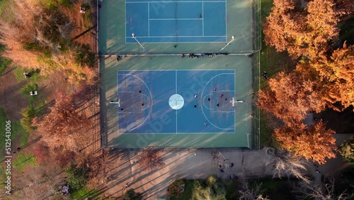 Static overhead view of a group of people playing basketball on the courts of Parque Araucano with autumn trees around. Santiago, Chile photo