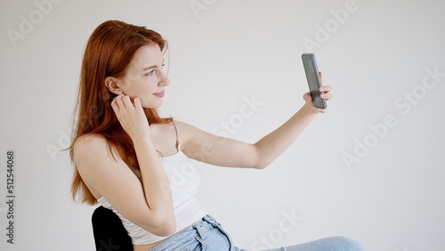 Beautiful young woman takes a selfie photo on the phone. 