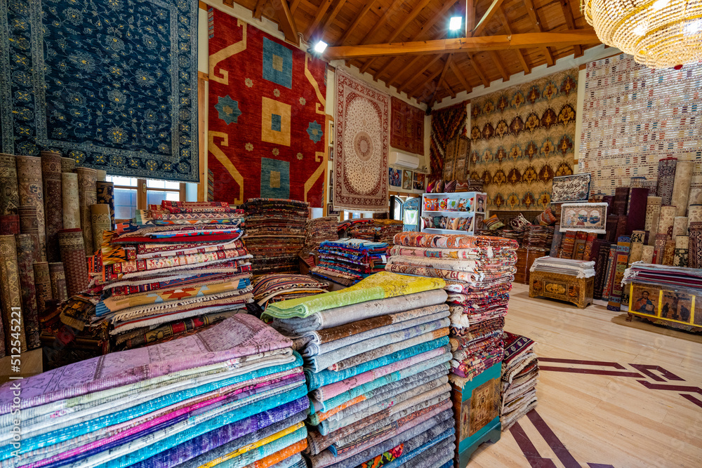 Large stacks of oriental  rugs in a store. Colorful carpet market. Turkey