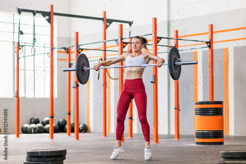 Fotografija Fit muscular young woman performing a barbell snatch