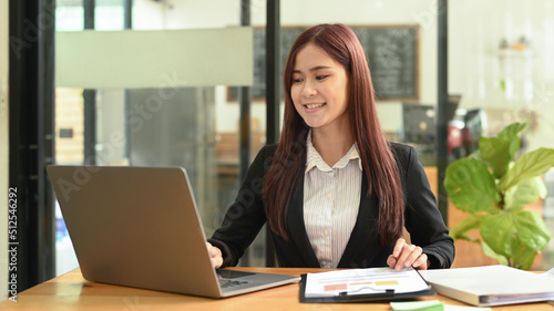 Charming asian businesswoman using laptop computer at coffee shop