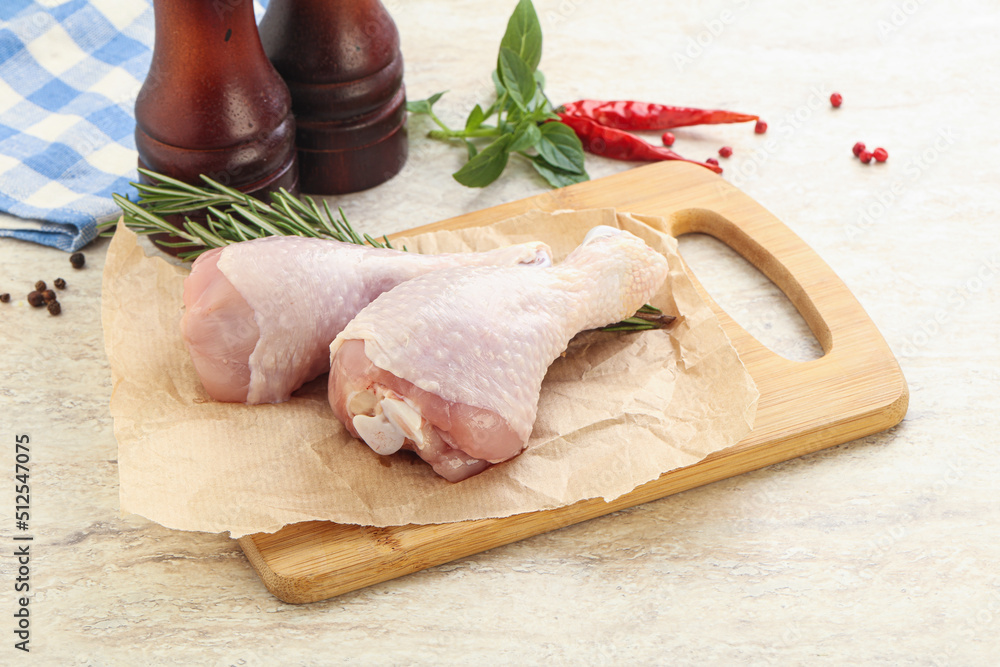 Raw chicken leg over board