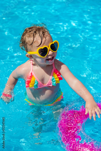A child swims in a pool with a circle. Selection focus.