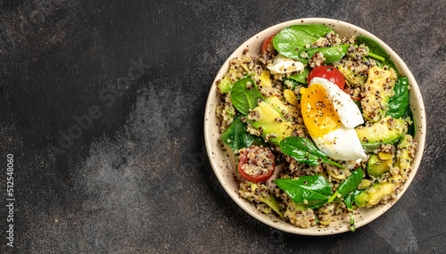 Quinoa buddha bowl with avocado, egg, tomatoes, spinach and sunflower seeds on a dark background. Homemade food. Healthy, clean eating. Vegan or gluten free diet, Long banner format. top view