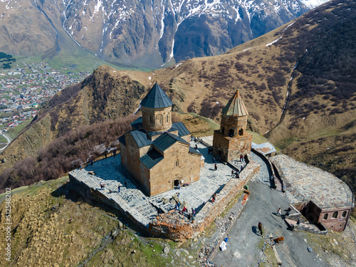 A stunning aerial view of Holy Trinity Church (Gergeti Trinity Church) near the village of Stepantsminda in Georgia photo