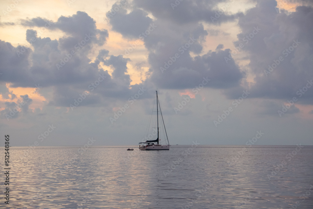 sailing yacht, cumulus clouds over the sea at sunset