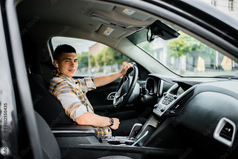 Man driving a car wearing a wireless earphone Man driving a car wearing a wireless earphone