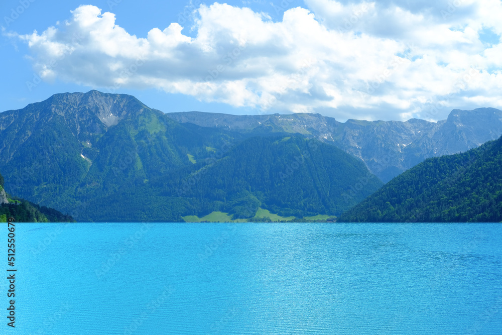 picturesque lake Achensee in Austria, green mountains rises above the calm expanse of water, the concept of the beauty of nature, vacation by the reservoir, water sports, resort place tyrol