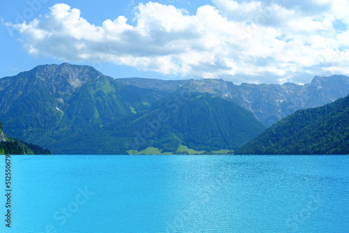 picturesque lake Achensee in Austria, green mountains rises above the calm expanse of water, the concept of the beauty of nature, vacation by the reservoir, water sports, resort place tyrol