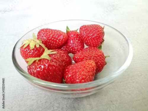 Fresh and ripe strawberries filling glass bowl. Stop motion concept